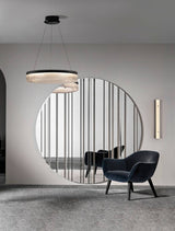 Moderne Pauline LED Pendelleuchte in Schwarz, schwebend über einem stilvollen Raum mit rundem Spiegel und Sessel.
