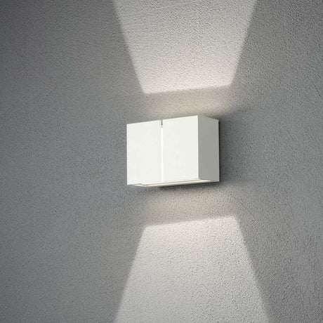 Pavia LED Außenwandleuchte in Weiß an einer Wand installiert, mit sanftem Lichtschein.