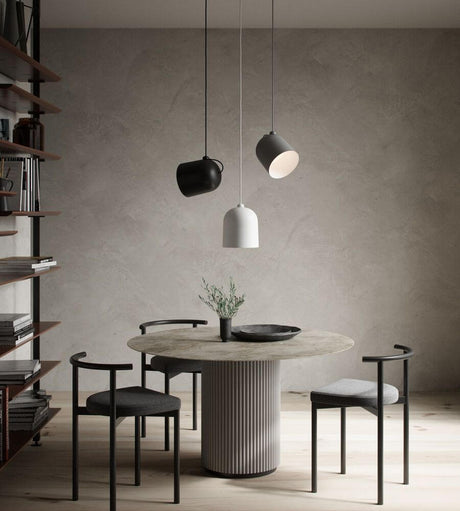 Vinkel pendel i et moderne rum over et spisebord med stilfulde stole og minimalistisk indretning.