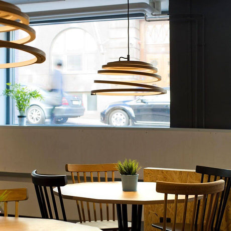 Aspiro 8000 pendant light made of wood Ø 50 cm in a modern interior above a table.