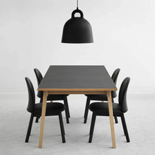 Luminária pendente Bell L Ø 55cm Preta sobre uma mesa de jantar moderna com cadeiras pretas.