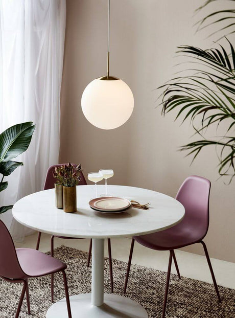 Pendant light Grant 35 above a modern table with pink chairs in a stylish dining area.