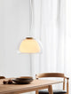 Pendelleuchte Jelly in modernem Design, beleuchtet einen Essbereich mit warmem Licht und elegantem Glas.