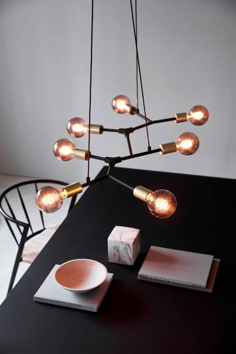Josefine 7-spot pendant light in a modern design above a table with minimalist decorations