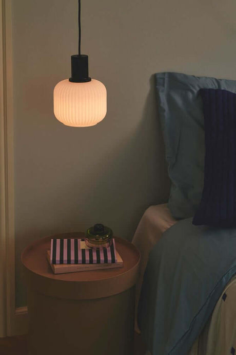 Milford Mini pendant light hangs above a bedside table in a modern bedroom.