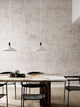 Pendelleuchte Nori 39 über einem minimalistischen Esstisch mit hellen Wänden und eleganten Stühlen.