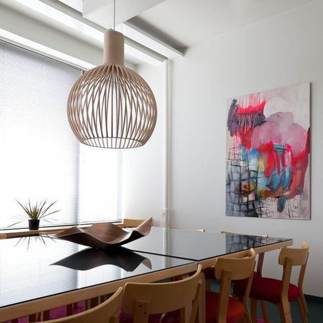 Octo Small 4241 pendant light made of wood Ø 45 cm in a modern dining room above a black table.