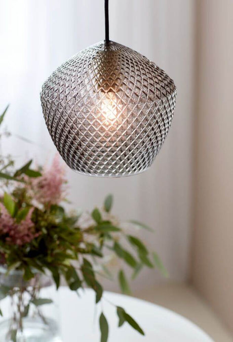 Orbiform pendel med femkantet glasform og diamantmønster, som giver et glamourøst lysdesign.