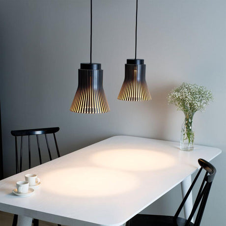 Pendant light Petite 4600 made of wood Ø 20cm above a modern dining table with a flower.