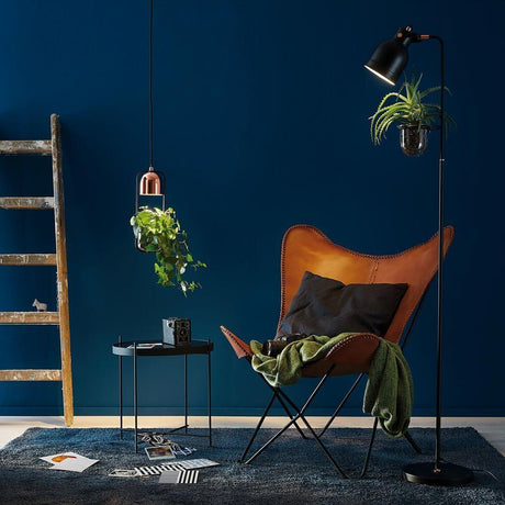 Taklampe plantebelysning Neordic Fanja svart, kobber over en lenestol i Urban Jungle-stil.