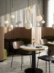 Pendelleuchte Shapes 27 im eleganten Restaurant mit organisch geformtem Design und Messingdetails.