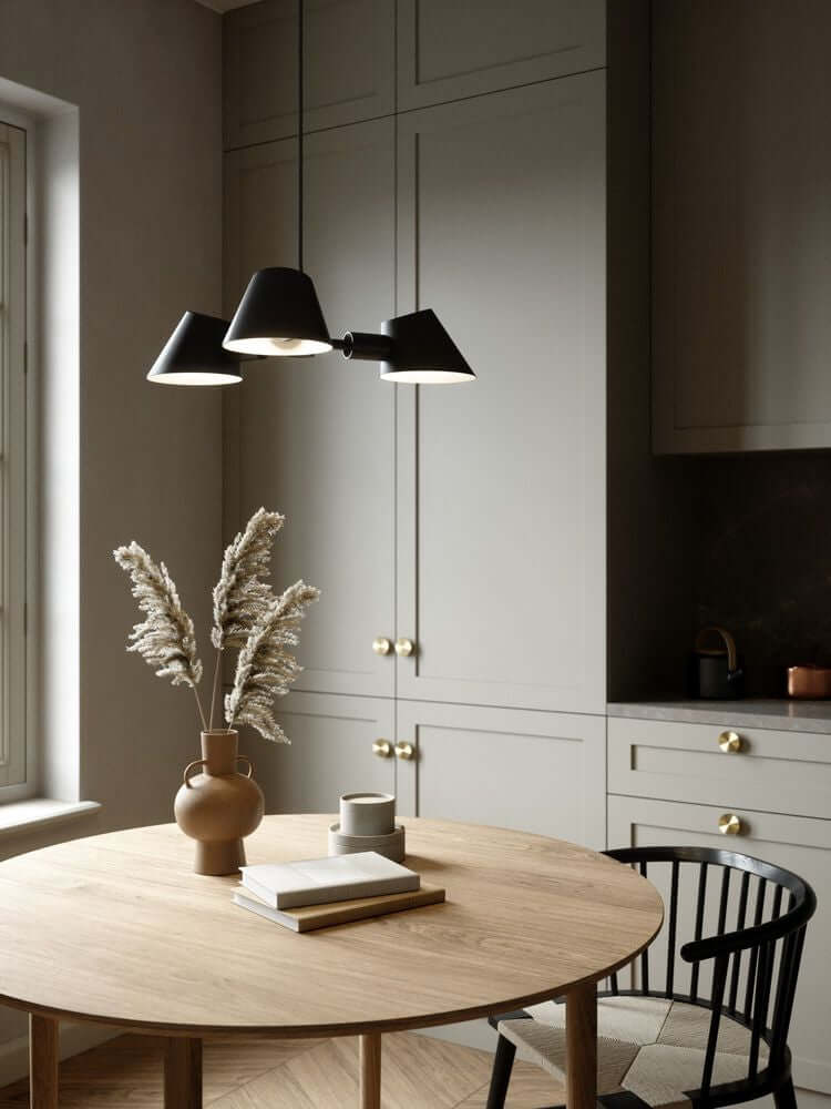 Pendelleuchte Stay 3-Spot im modernen Küchenambiente über einem Holztisch.