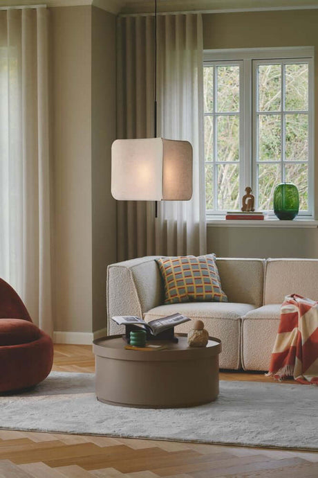 Tinto pendant light in a modern living space above a cozy sofa and table.