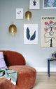 Pendelleuchte Uma 23 und Sofa in modernem Wohnraum mit bunten Bildern an der Wand.