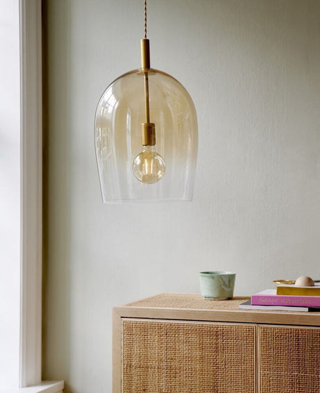 Pendelleuchte Uma 30 in modernem Design, hängend über einem Möbelstück mit stilvollem Hintergrund.