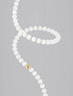 Perla LED Pendelleuchte 67-flammig Ø 79cm 3000K mit eleganten weißen Perlen und goldenen Akzenten.