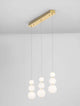 Perla LED Pendelleuchte Balken 70cm 9-flammig 3000K Gold mit drei weißen Glaskugeln und goldenem Deckenbalken.