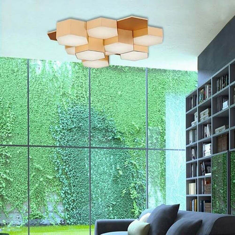 Pettine LED plafonnier design 43W, 3000K doré satiné dans un espace de vie moderne avec un mur vert.