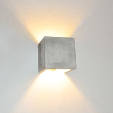 s.luce Applique Plinth in cemento grigio con effetto luminoso indiretto in design moderno.