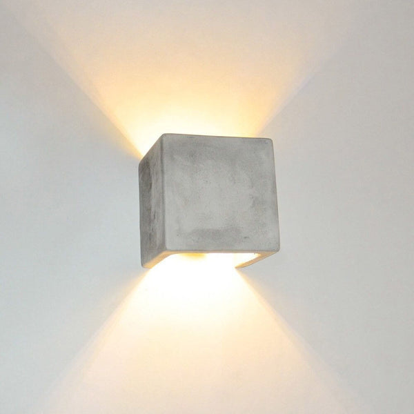 s.luce Applique Plinth in cemento grigio con effetto luminoso indiretto in design moderno.