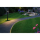 Plug & Shine LED Pollerleuchte Plate Anthrazit beleuchtet den Gartenweg und die Umgebung bei Nacht.