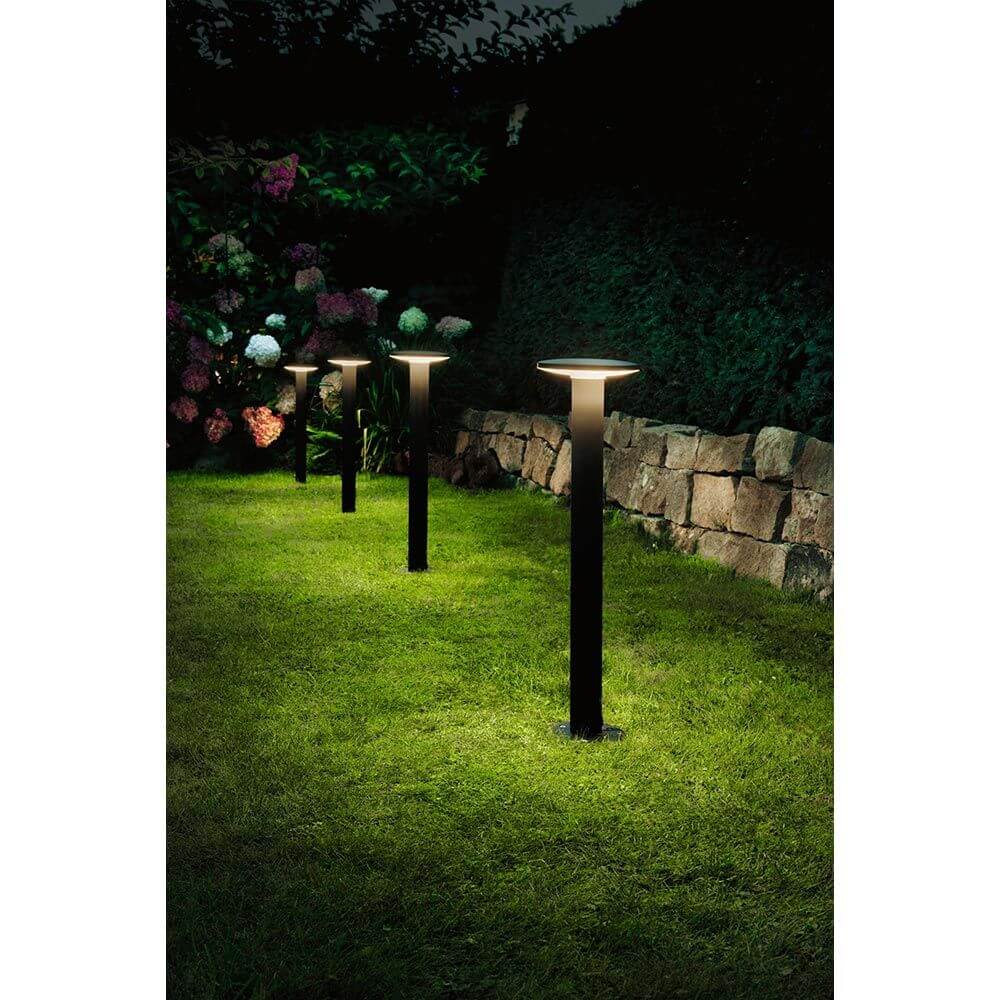 Plug & Shine LED Pollerleuchte Plate Anthrazit im Garten, beleuchtet Wege und Plätze bei Nacht.