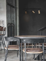Pogno 3-light pendant light Black, Gold in a modern dining room with wooden chairs.