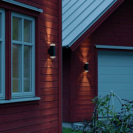 Pollux Wandleuchte 2-flammig an der Wand eines roten Hauses, dekorative Außenbeleuchtung.