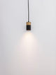 Pongo Pendelleuchte Cover Unten Ø 5,6cm Schwarz, Gold an einer Wand montiert, strahlt sanftes Licht.