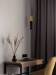 Pongo Pendelleuchte Cover Unten Ø 5,6cm Schwarz, Gold über einem modernen Tisch und Vase mit Trockenblumen.