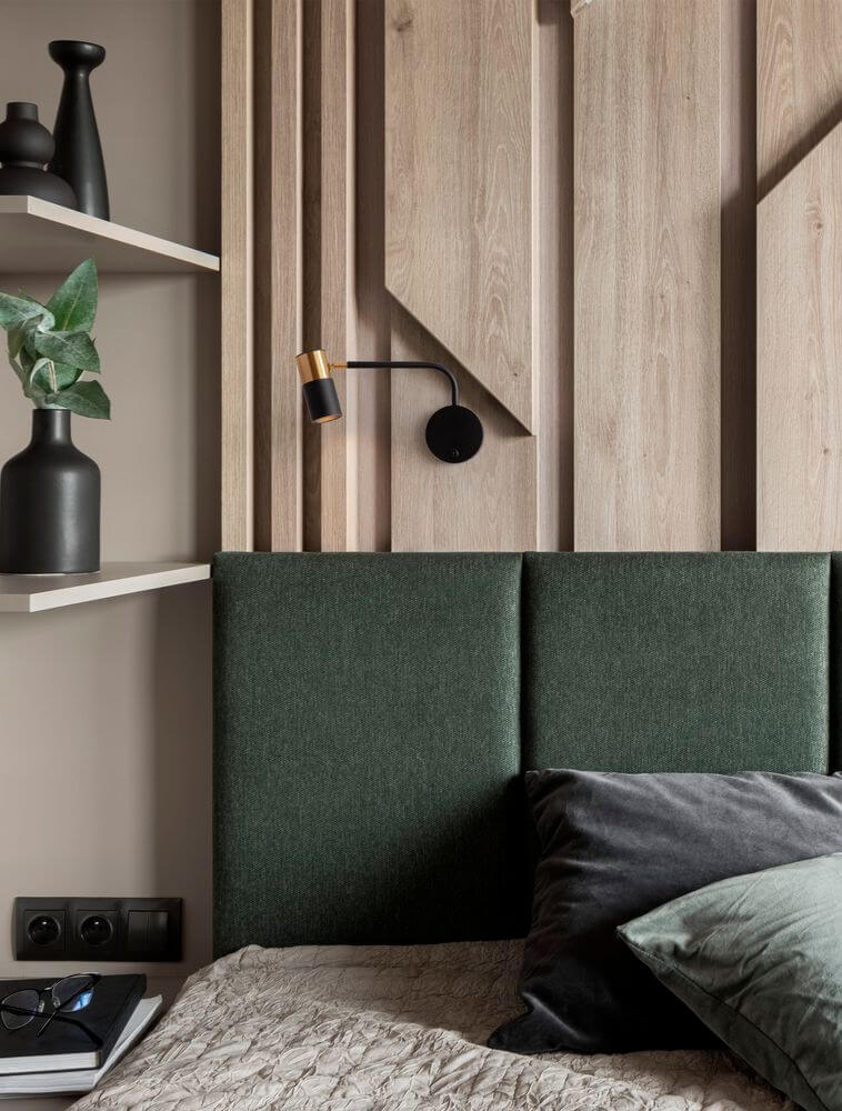 Pongo Wandleuchte Schwarz, Gold an einer modernen Wand in einem Schlafzimmer