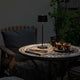 Positano Outdoor LED Akku Tischleuchte auf einem Tisch im Freien, ideal für dimmbares Licht bei 2700 und 3000 Kelvin.