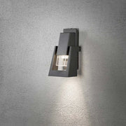 Lámpara de pared exterior Potenza en antracita IP54 en una pared, elegante y moderna con luz cálida.