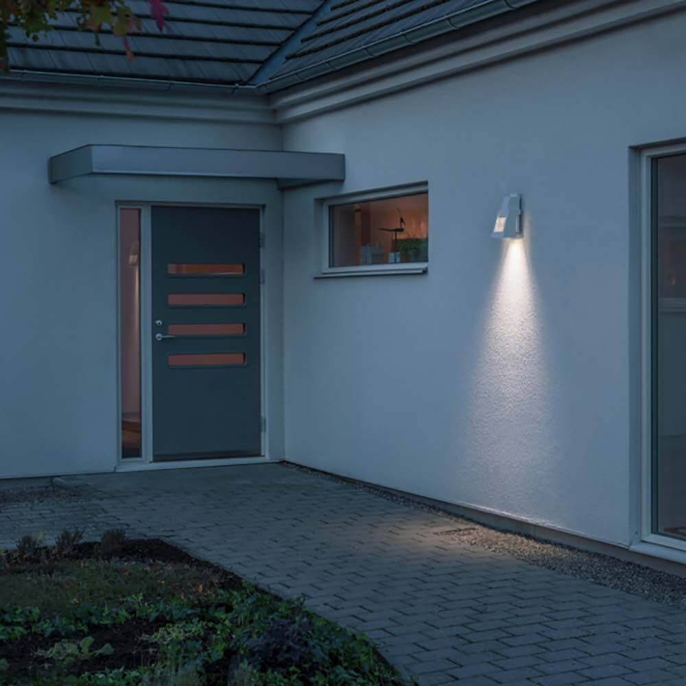 Potenza LED Außen Wandlampe IP54 an einer Hauswand, die den Eingang beleuchtet.