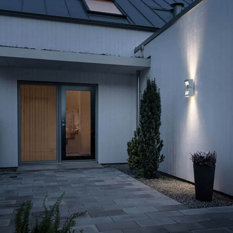 Potenza LED Außenwandleuchte an der Wand eines modernen Hauses in der Abenddämmerung.