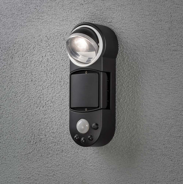 Lâmpada de parede LED a bateria Prato com sensor de movimento preta montada numa parede.