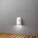 Prato Batterie LED Wandaufbauleuchte mit Bewegungsmelder 12V Weiß an einer Wand montiert, strahlendes Licht auf Holzuntergrund.