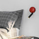 Press LED Wand-Leselampe an einer Wand über einem Bett mit Kissen und Decke.