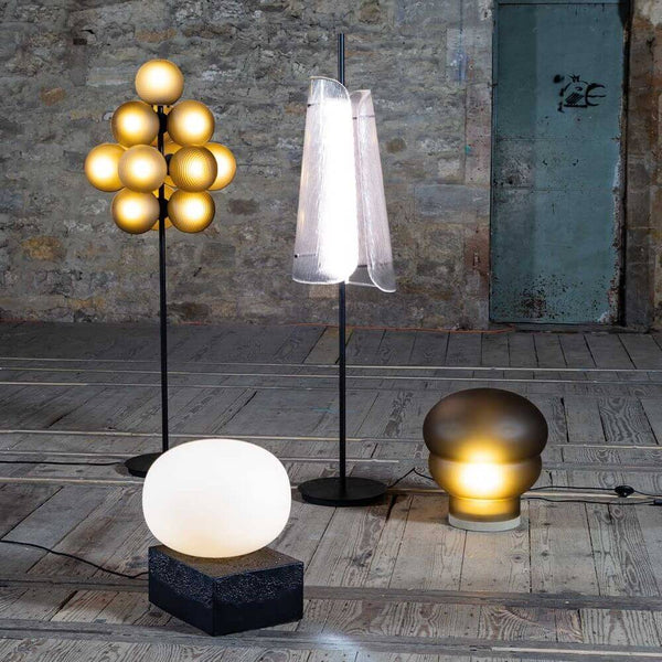 Pulpo LED Stehlampe Bent Two Glass und weitere Designlampen in einem modernen Raum.