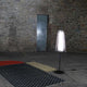 Pulpo LED Stehlampe Bent Two Glass in einem rustikalen Raum mit Holzfußboden und Teppichen.