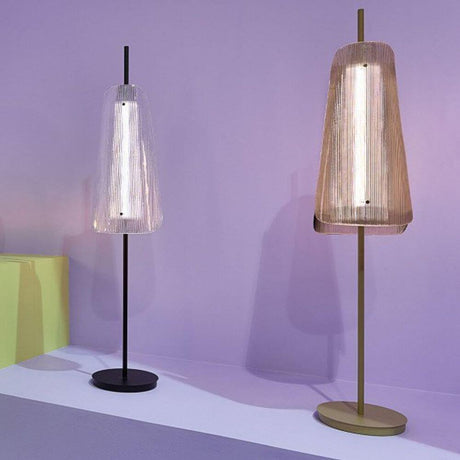 Pulpo LED Bent One Glass floor lamp in black and gold with an elegant glass design against a purple background.