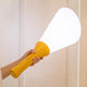 Flash Akku LED Tischlampe mit Fernbedienung in Hand gehalten, strahlendes Licht für ein helles Zuhause.