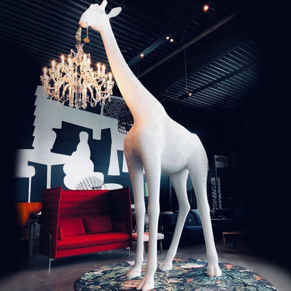 Giraffe in Love Stehleuchte 400cm Lebensgroß mit Kronleuchter als Maul in modernem Wohnraum.