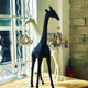 Giraffe in Love XS Stehleuchte 100cm mit Kronleuchter in Giraffen-Design in einem modernen Raum.