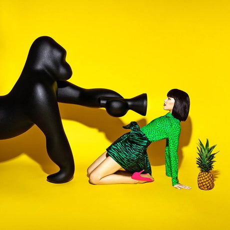Kong XL floor lamp gorilla with a stylishly dressed woman in front of a yellow background and a pineapple.