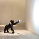 Kong XS Tischlampe Gorilla leuchtet mit verstellbarem Arm auf die Wand in einem modernen Innenraum.