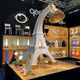 Paris XL Stehleuchte Eifelturm 225cm in einem modernen Ausstellungsraum, umgeben von dekorativen Objekten.