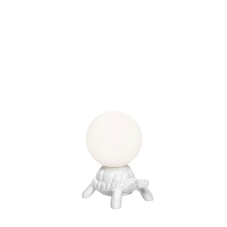 Turtle Carry XS LED rechargeable table lamp on a white turtle with a glowing sphere.