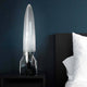 V-2 Schneider Raketen Tischleuchte auf Nachttisch vor blauer Wand, modernes Design mit nostalgischem Flair.