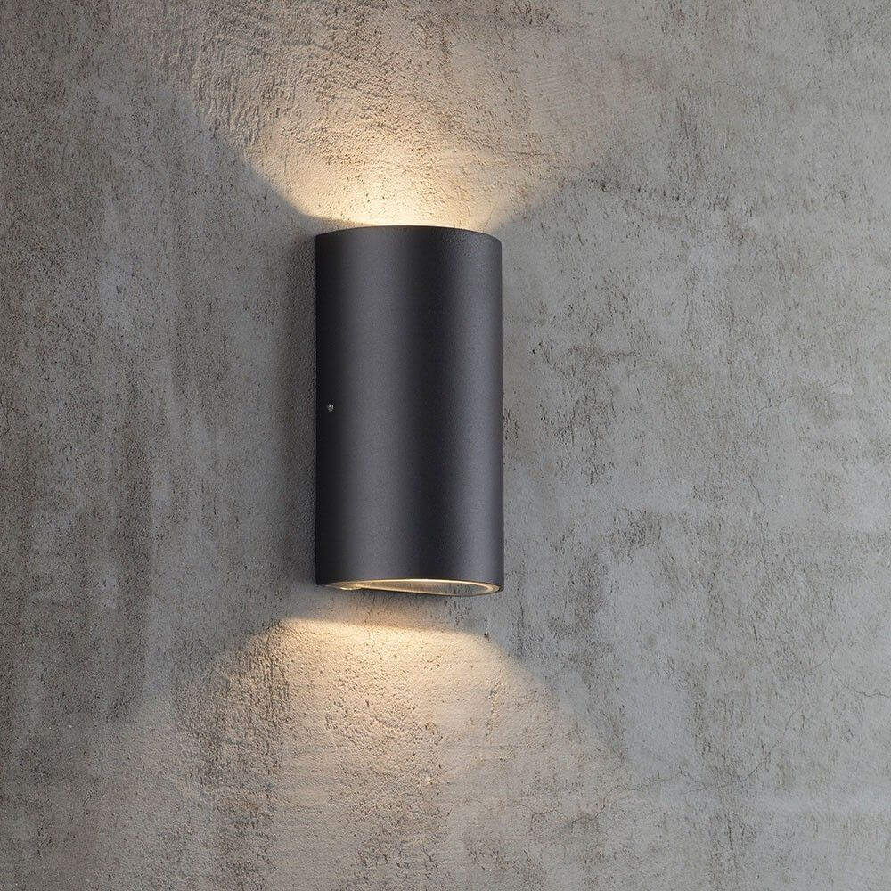 Rold LED Außen-Wandleuchte IP44 Schwarz an einer Wand, minimalistische Design mit Lichtstrahlung nach oben und unten.